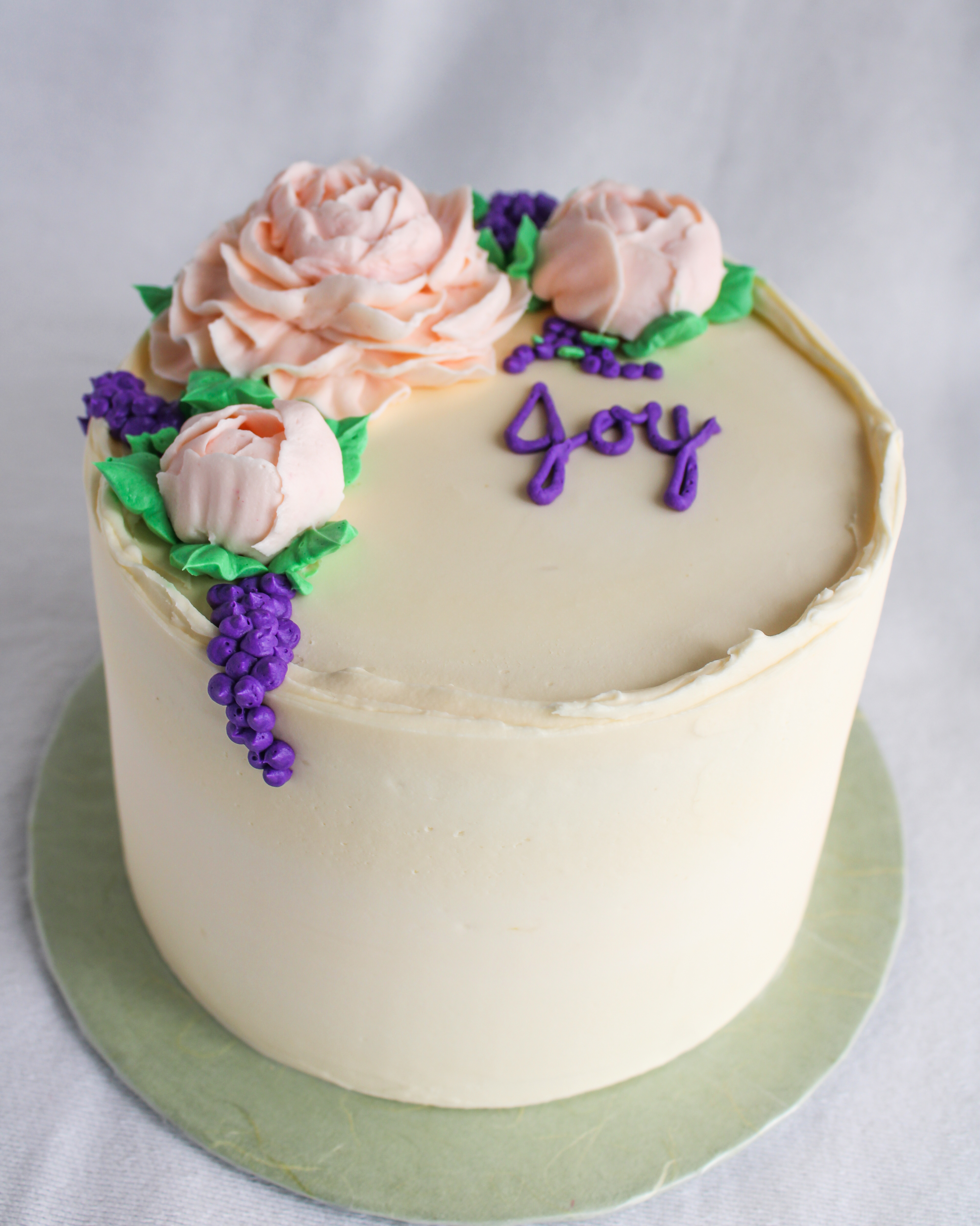 small elegant birthday cake with pink and purple flowers