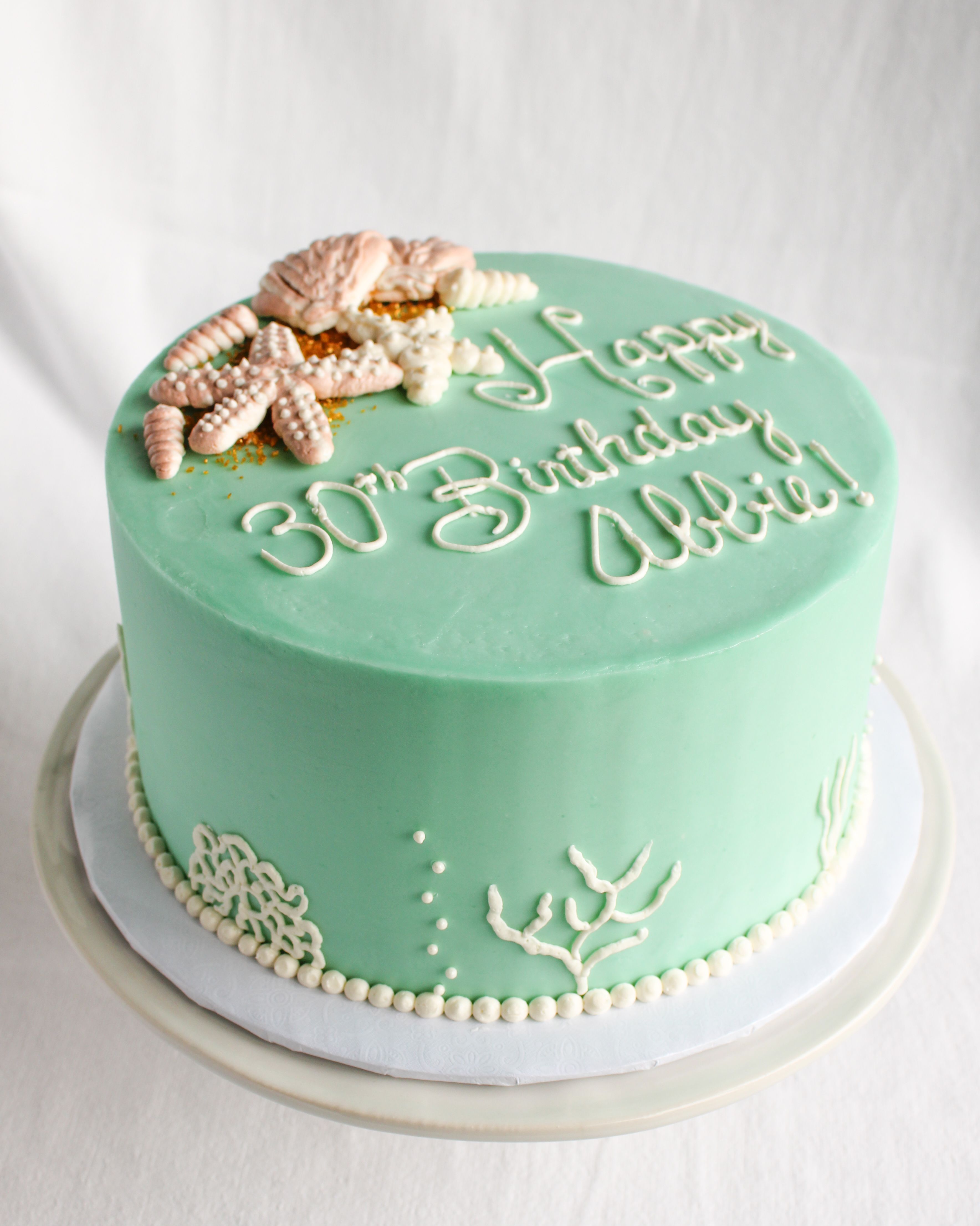 under the sea green cake with coral and buttercream sea shells and starfish