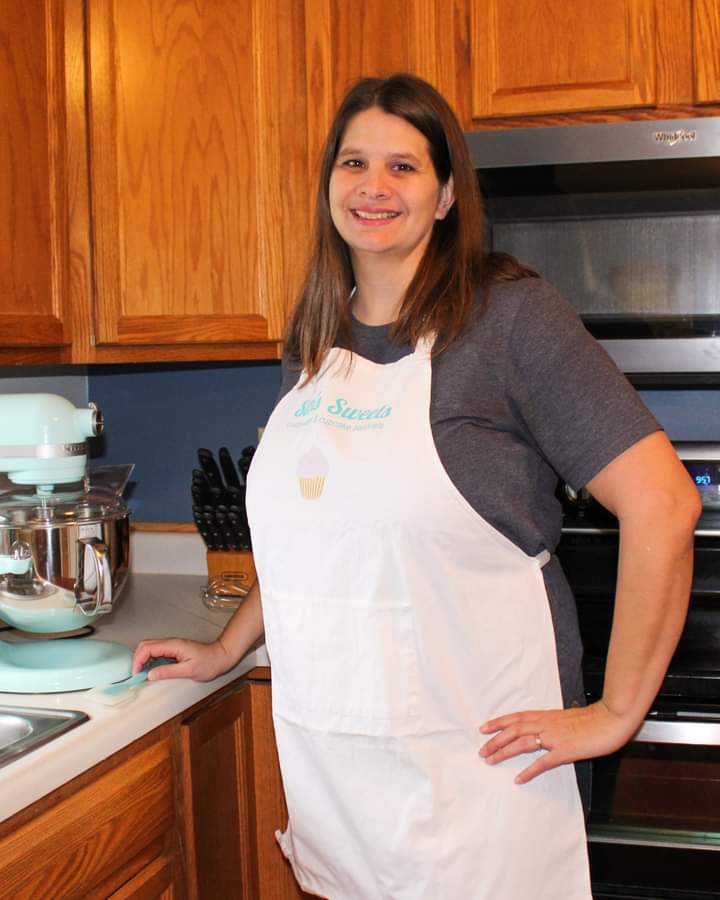 Sam is standing in her kitchen, in front of her mixer and oven